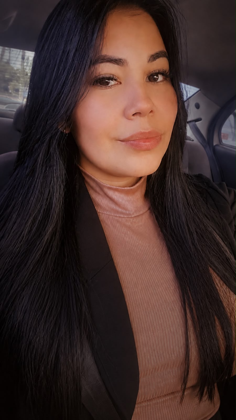 Sthefanny Peres, fundadora da PHAROS, com cabelos longos escuros, blazer preto e blusa rosada.